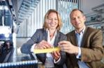 The two company founders in the laboratory holding reaction vessels.