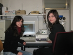 Susanne Domschke und Tanja Becker sitzen vor einem Lasermikroskop.