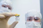 Person holding a vial with vaccine.