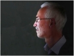 Zu sehen ist das Gesicht eines grauhaarigen Mannes mit Brille im Profil.