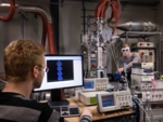 Zu sehe sind zwei Junge Wissenschaftler umgeben von physikalischen Messgeräten.