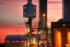 The photo shows a white factory building against an orange-red evening sky.<br />
